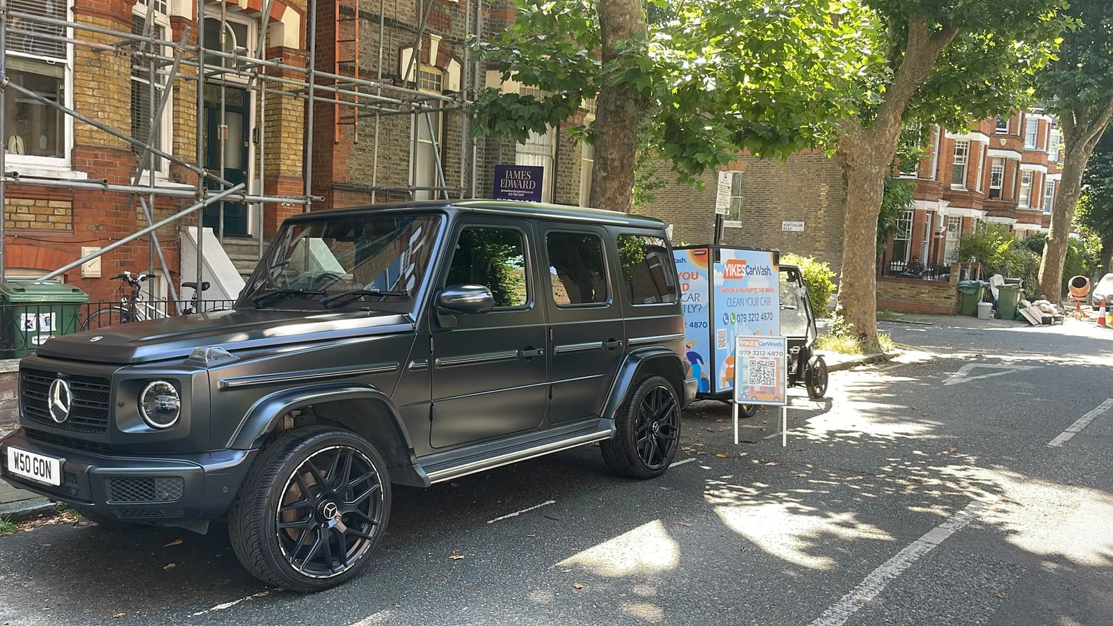 Yikes cargo e-bike wash rig beside a Mercedes G-Class on a leafy London street